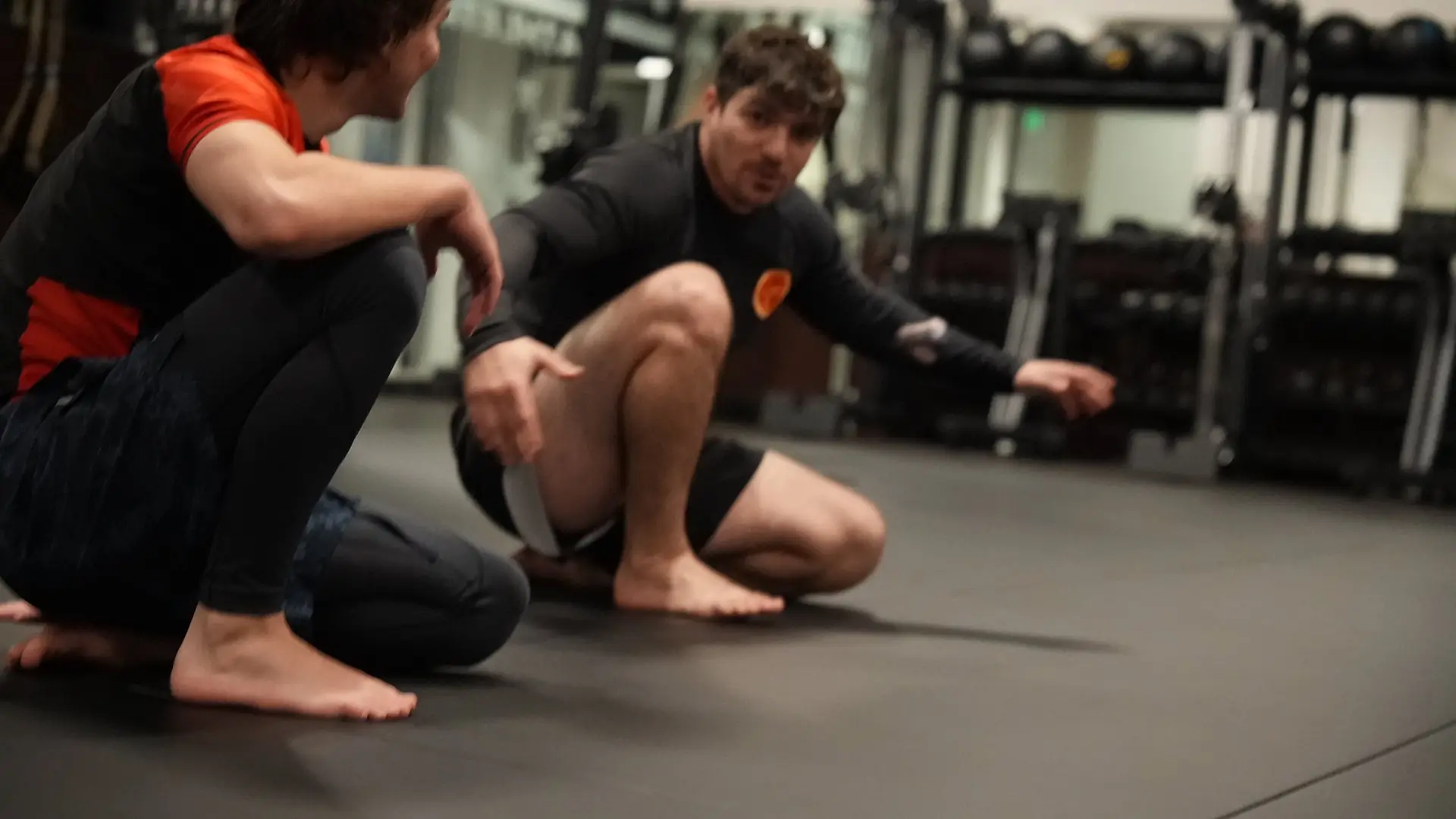 Coach Nick explaining a position to a student during a no-gi session